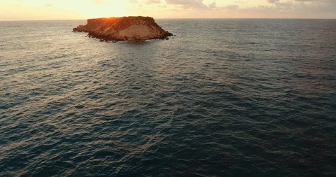 Sunset over the wavy sea. shooting from the air. Rocky coast. island on the hori Stock Footage 97301184
