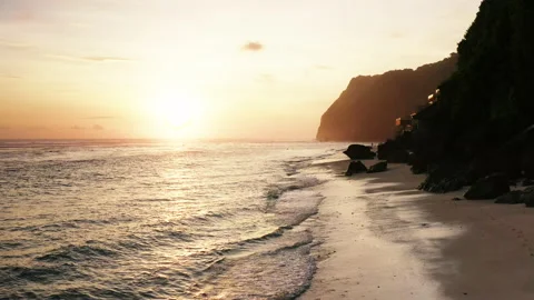 Sunset over a white sand beach along the cliff in Bali Stock Footage 147906011