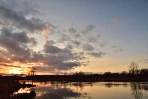 Sunset over a wide river on a cool spring day. Fish eye lens. Stock Photos