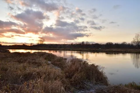 Sunset over a wide river on a cool spring day. Fish eye lens. Stock Photos