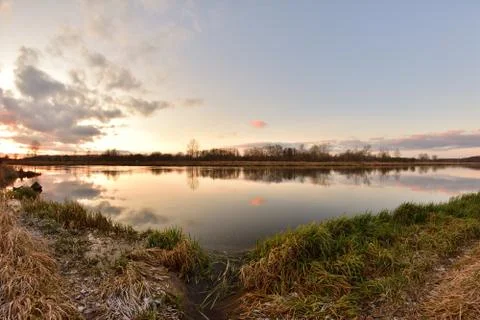 Sunset over a wide river on a cool spring day. Fish eye lens. Stock Photos