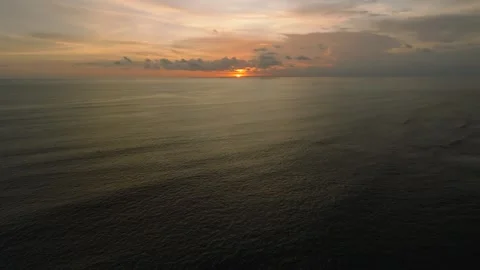 The sunset paints the sky over the tranquil ocean with a warm afterglow Stock Footage 280251278