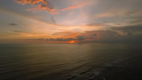 The sunset paints the sky over the tranquil ocean with a warm afterglow Stock Footage 280510757