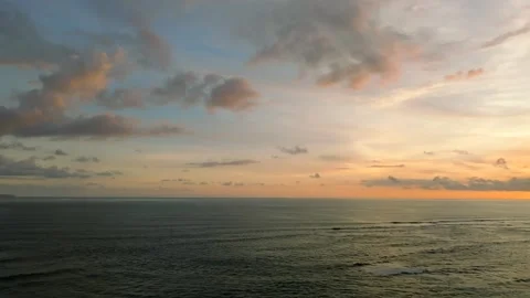 The sunset paints the sky over the tranquil ocean with a warm afterglow Stock Footage 280546551