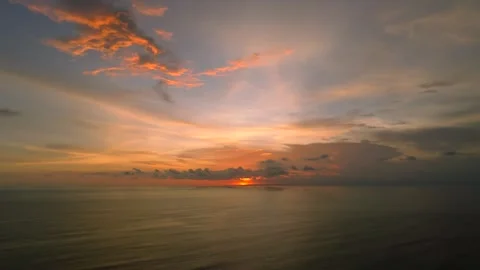 The sunset paints the sky over the tranquil ocean with a warm afterglow Stock Footage 280546692