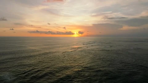 The sunset paints the sky over the tranquil ocean with a warm afterglow Stock Footage 280708471