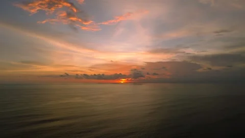 The sunset paints the sky over the tranquil ocean with a warm afterglow Stock Footage 280966492