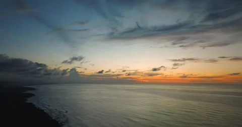 The sunset paints the sky over the tranquil ocean with a warm afterglow Stock Footage 310473998
