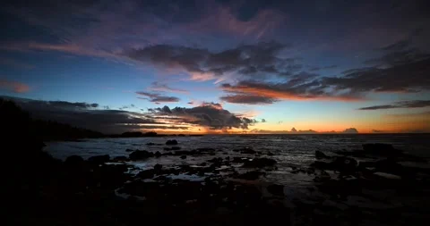 The sunset paints the sky over the tranquil ocean with a warm afterglow Stock Footage 311594789