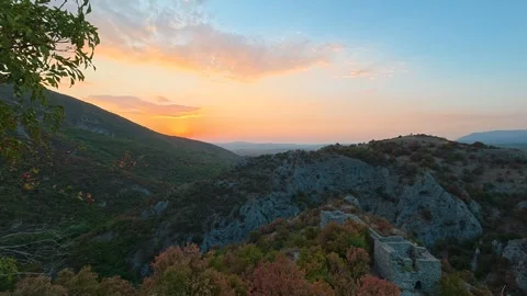 Sunset paints sky with warm orange hues. Soko Grad, Serbia 動画素材 345897506
