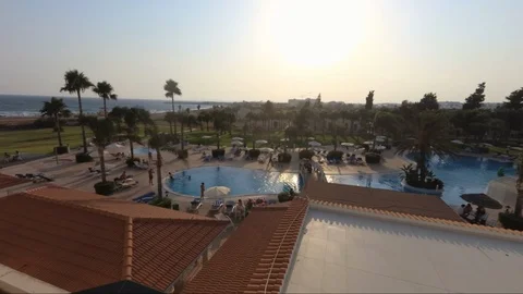 Sunset pan shot from hotel. Sea, pool, palms, beach. Stock Footage 114987341