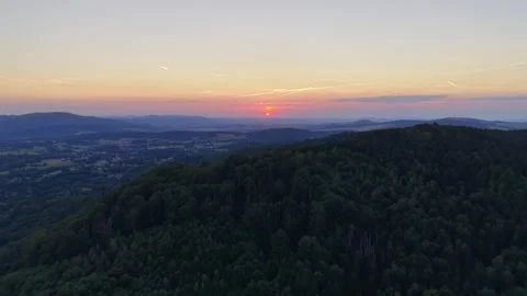 Sunset panorama over forested hills and distant valley with settlement Stock Footage 345170891