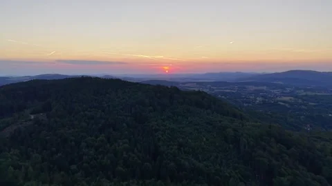 Sunset panorama over forested hills and distant valley with wind turbines along Stock Footage 345170908