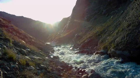 Sunset panorama with a turbulent and cloudy glacial stream Stock Footage 153536032