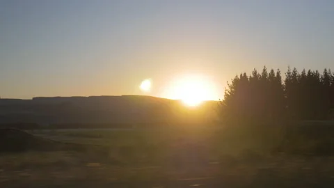 The sunset passes through the trees from the car, in New Zealand Stock Footage 219164351