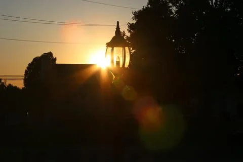 Sunset passing through lamp post with Bokeh 库存照片