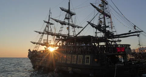 Sunset passing through silhouette of pirate ship on sea Stock Footage 298867061