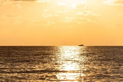 Sunset path on the sea with a ship. Stock Photos