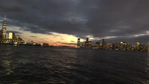 A sunset peaking through the grey clouds above a flowing river Stock Footage 164541500