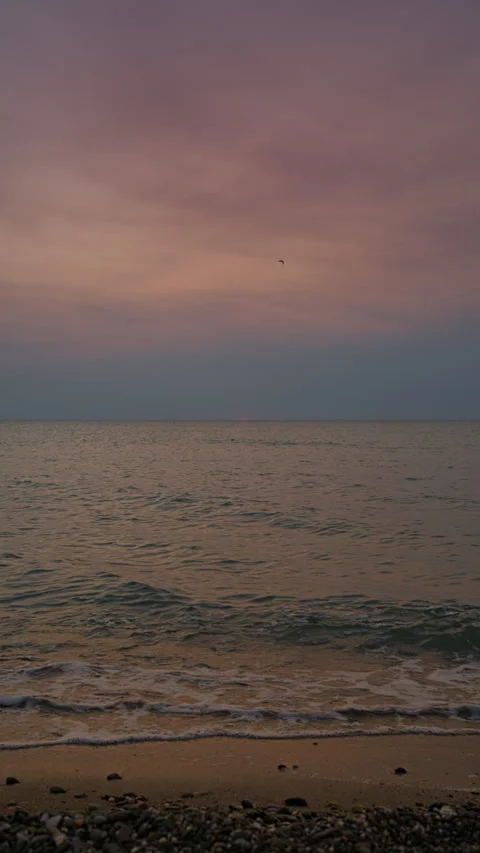 Sunset at pebble beach with gentle waves and warm breeze. Stock Footage 308485573