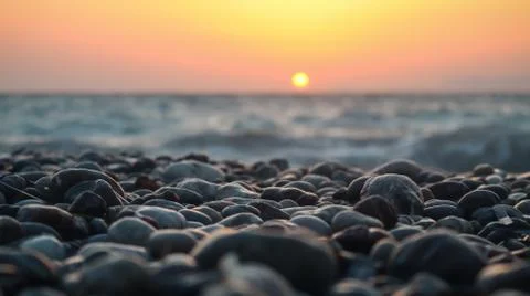 Sunset on a pebbled beach Stock Photos