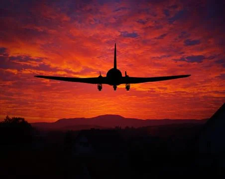 Sunset with a plane silhouette Stock Photos