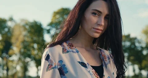 At sunset portrait smiling young attractive woman look at camera in a summer Video stock 112620301