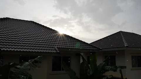 Sunset in rainy day scene, slow motion water pouring rain falling on roof house Stock Footage 94172702