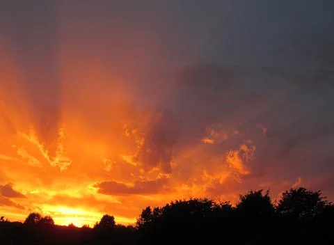 Sunset. The rays of the sun in the clouds. Orange lilac Foto stock