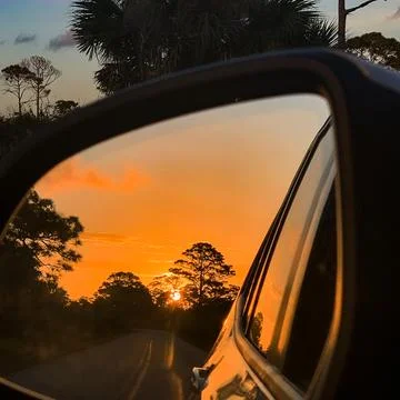 Sunset in the rear view mirror Stock Photos