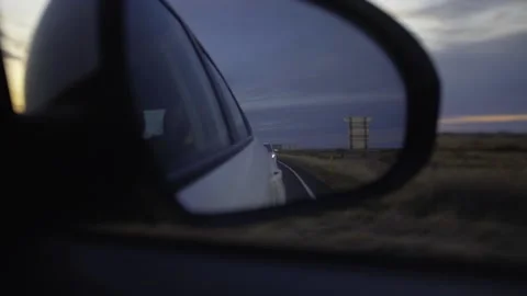 Sunset in the rearview mirror of a car Stock Footage 130458959