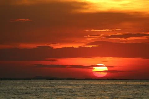Sunset on red orange sky back soft evening cloud over horizon sea Stock Photos