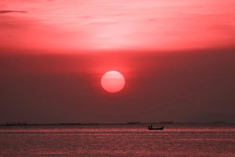 Sunset on red sky back evening cloud over twilight and fishing on sea Photos