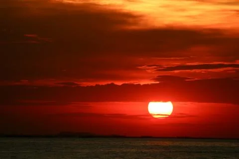 Sunset on red yellow sky back soft evening cloud over horizon sea 写真素材