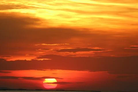 Sunset on red yellow sky back soft evening cloud over horizon sea Stock Photos