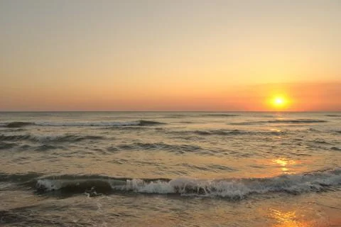 Sunset reflected on the beach waves Stock Photos