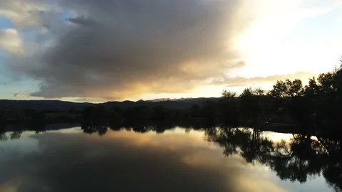 Sunset reflected in calm waters - Drone pans around Stock Footage 137887103