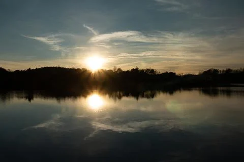 Sunset reflected in the lake as a mirror image. Sunset over the mountains Stock Photos