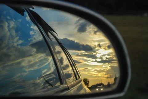 Sunset is reflected in the rearview mirror of a car Stock Photos