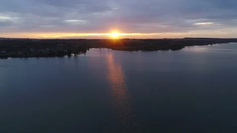 The sunset is reflected in the water. Autumn evening flight over the river. Video stock 141572061