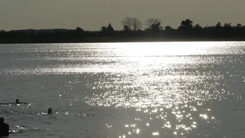 Sunset reflected in the water towards the reflection floating silhouettes of 스톡 동영상 115320830