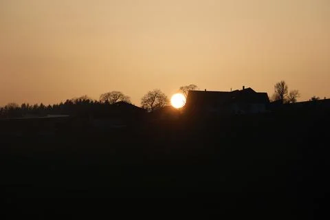 A sunset is reflected in the window of a house Foto stock
