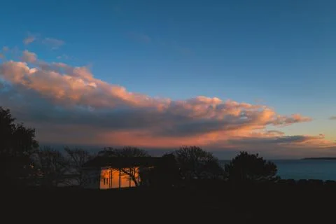 Sunset reflecting on the back of the boating pool building Stock Photos