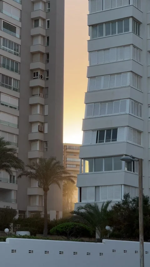 Sunset reflecting on modern apartment buildings in Alicante, Spain. Vertical Stock Footage 294387181