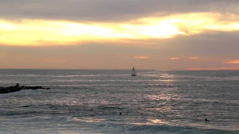 Sunset reflecting on ocean with surfers Video stock 82849848