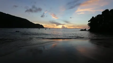 Sunset reflecting on sand with waves on Tobago beach (HD)c  Stock Footage 12657173