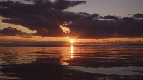 Sunset reflecting on surface of calm sea Stock Footage 168776503