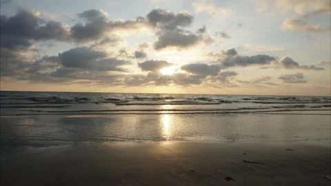 Sunset reflecting on wet sandy beach timelapse Video stock 325024795