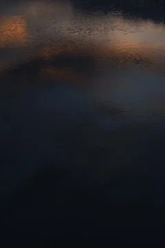 Sunset Reflection on Dark Rippling Water Foto stock