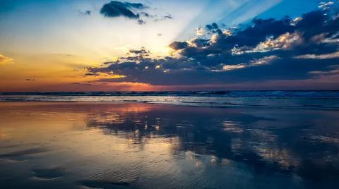 Sunset reflection ocean beach public waves sky teal orange blue Stock Photos
